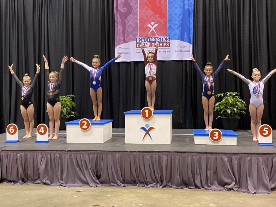 Several gymnasts on podiums at the USA Gymnastics Championships.