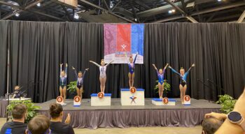 Several gymnasts on podiums at the USA Gymnastics Championships.