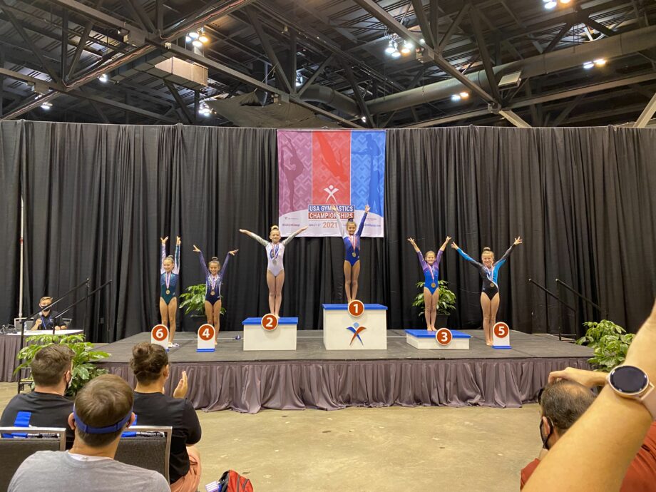 Several gymnasts on podiums at the USA Gymnastics Championships.