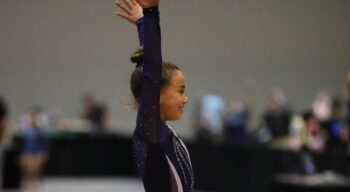 A gymnast salutes after a routine.