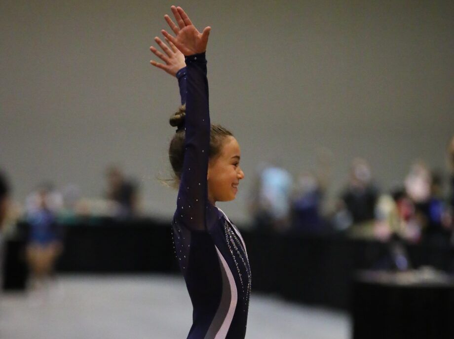 A gymnast salutes after a routine.