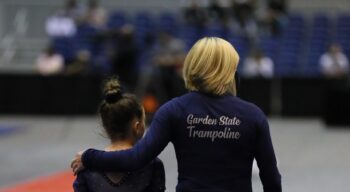 Coach Natasha walks with a gymnast.