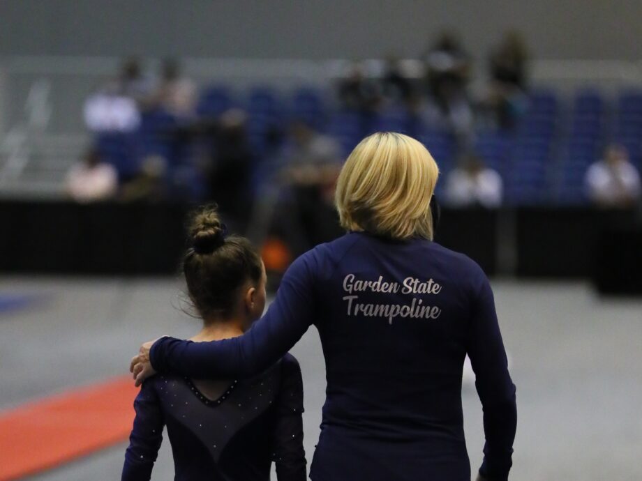 Coach Natasha walks with a gymnast.