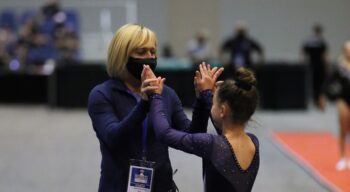 Coach Natasha congratulates a gymnast.