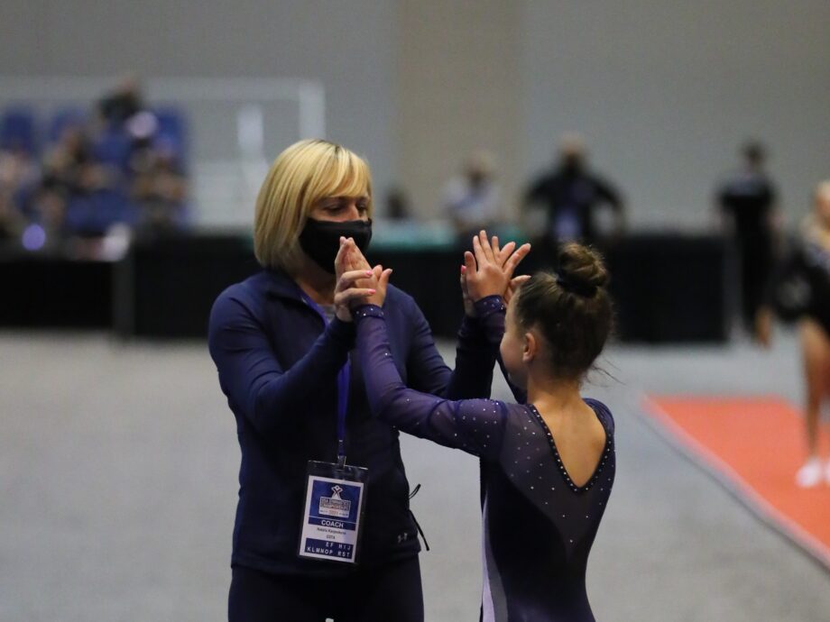 Coach Natasha congratulates a gymnast.