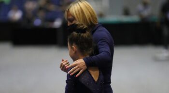 Coach Natasha walks with a gymnast.