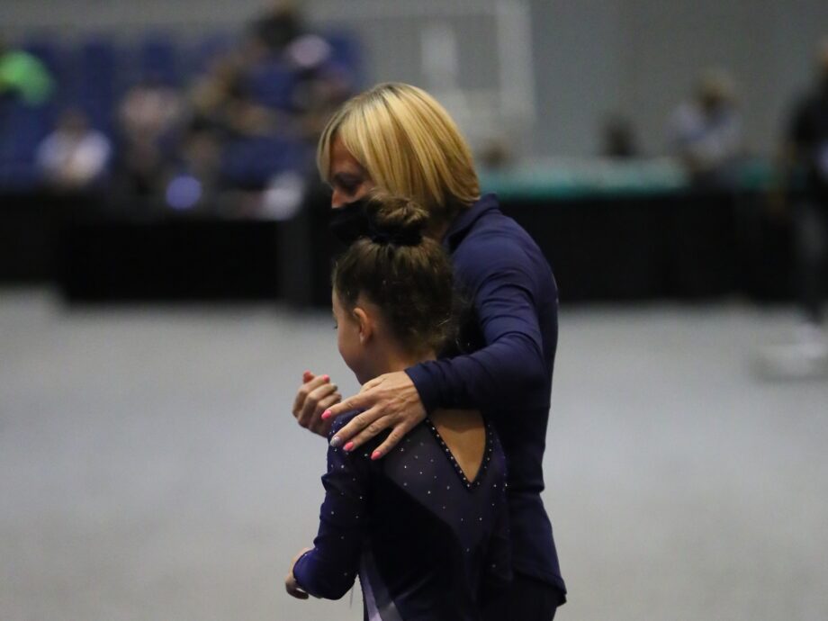 Coach Natasha walks with a gymnast.