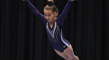 A girl enters a flp on trampoline.