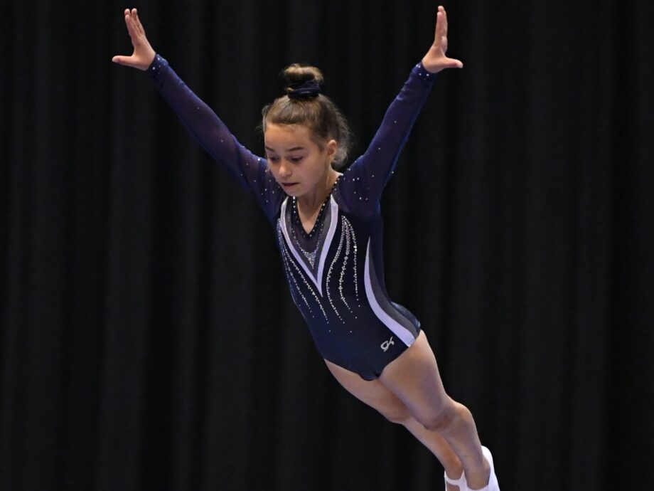 A girl enters a flp on trampoline.