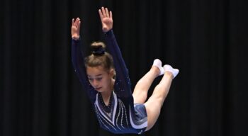 A girl keeps her posture while mid-air on trampoline.