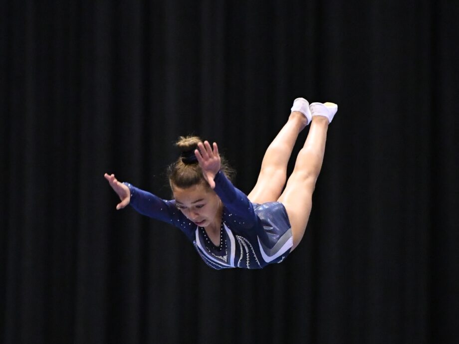 A girl in the air, landing from a flip.