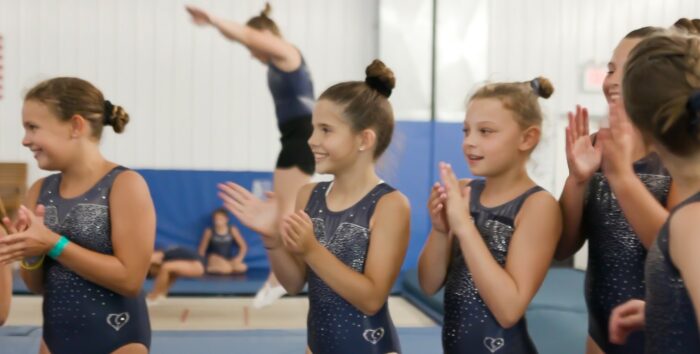 Several girls in a semi-circle clapping.